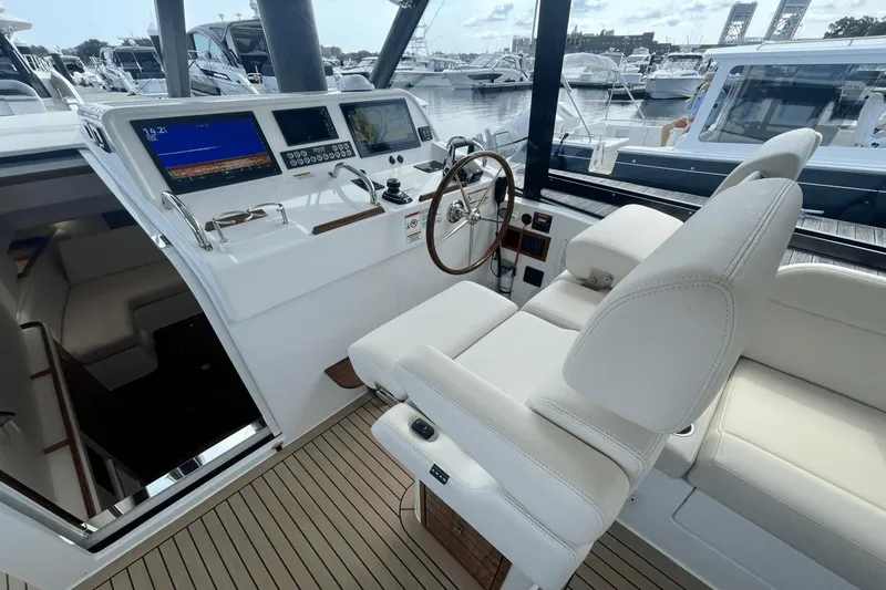 Slide: The Image of 2024 MJM 4 yacht helm with modern controls and luxurious seating at marina. - 14