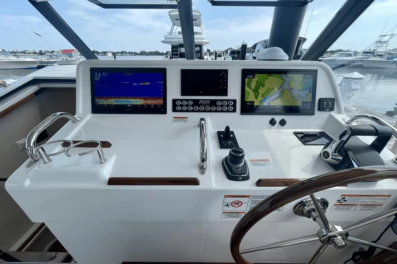 Slide: The Image of Helm of 2024 MJM 4 boat with navigation screens and controls at marina. - 16
