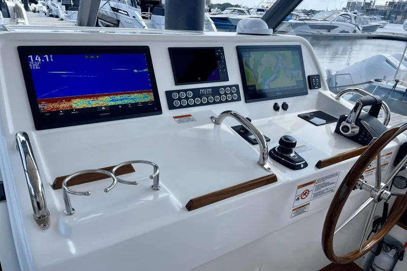Slide: The Image of 2024 MJM 4 boat helm with advanced navigation displays and controls at marina. - 17