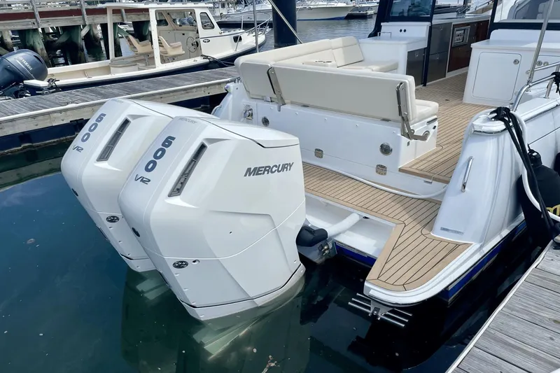 Slide: The Image of 2024 MJM 4 boat with dual Mercury 600 V12 engines docked at marina. - 2