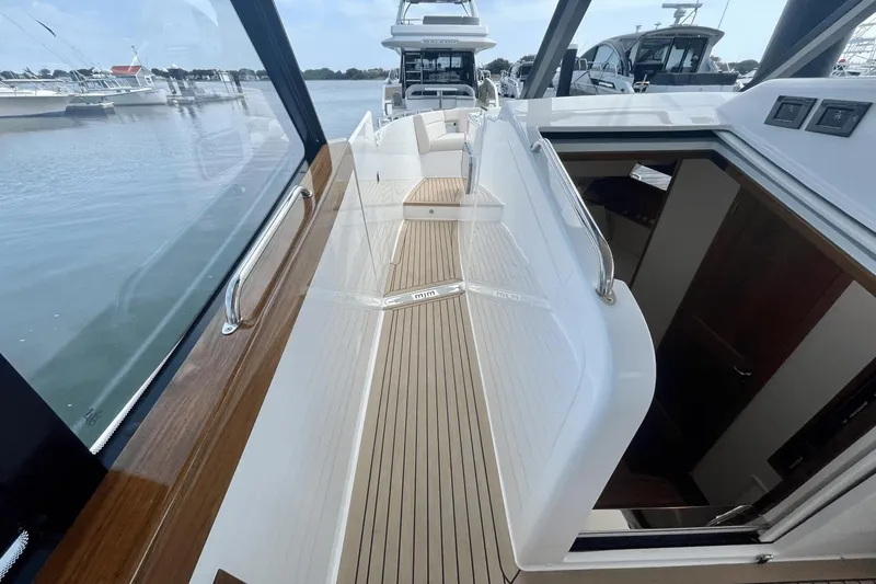 Slide: The Image of 2024 MJM 4 yacht deck with sleek design and wooden accents, docked at marina. - 28