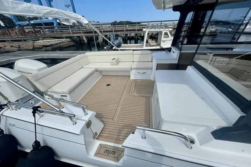 Slide: The Image of 2024 MJM 4 boat with spacious deck, comfortable seating, and modern design at a marina. - 3
