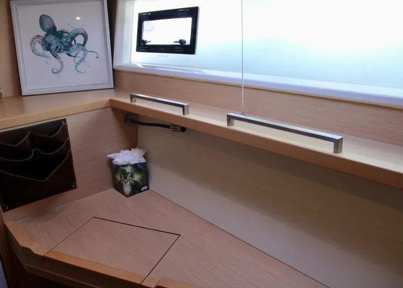 Slide: The Image of Lagoon 620 2015 yacht interior desk with window, artwork, and tissue box. - 12