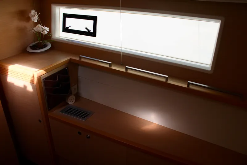 Slide: The Image of Interior of 2015 Lagoon 620 yacht with window and wooden cabinetry. - 16
