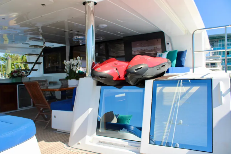 Slide: The Image of Lagoon 620 2015 yacht interior with red jet skis, blue seating, and dining area. - 33