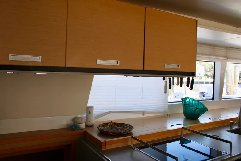 Slide: The Image of Modern kitchen interior of 2015 Lagoon 620 catamaran with wooden cabinets and large windows. - 35