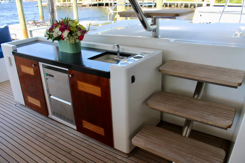 Slide: The Image of Outdoor kitchen on a 2015 Lagoon 620 yacht with wooden steps and floral arrangement. - 39