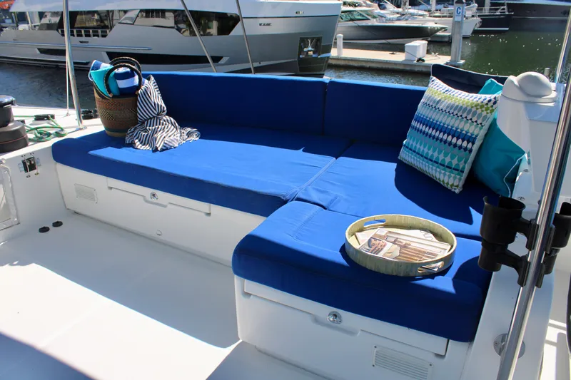 Slide: The Image of Spacious seating area on a 2015 Lagoon 620 yacht with blue cushions and decorative pillows. - 45