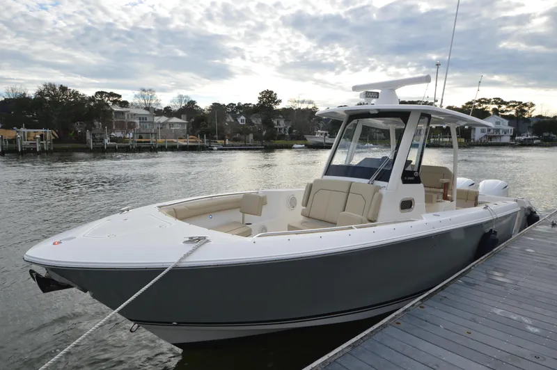 Slide: The Image of 2019 Pursuit S 288 Sport boat docked by waterfront homes. - 11