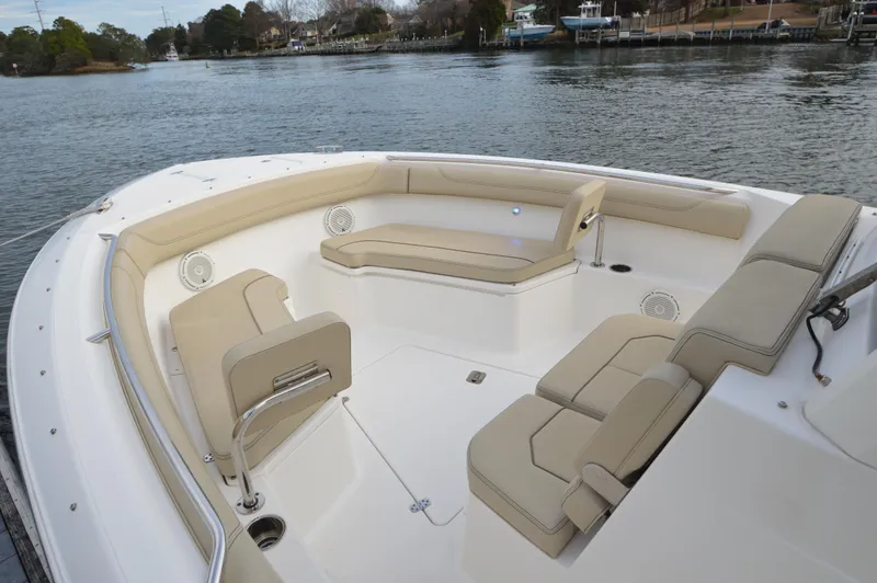 Slide: The Image of 2019 Pursuit S 288 Sport boat interior with beige seating, on a calm waterway. - 14