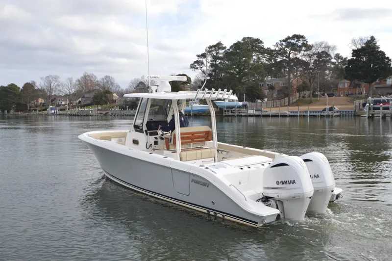 Slide: The Image of 2019 Pursuit S 288 Sport boat with twin Yamaha engines on a calm waterway. - 2