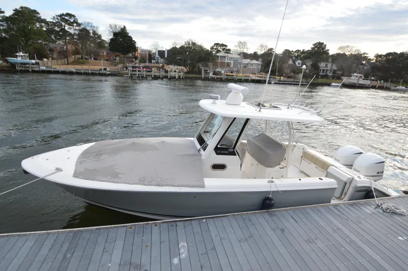 Slide: The Image of 2019 Pursuit S 288 Sport boat docked by waterfront homes. - 27