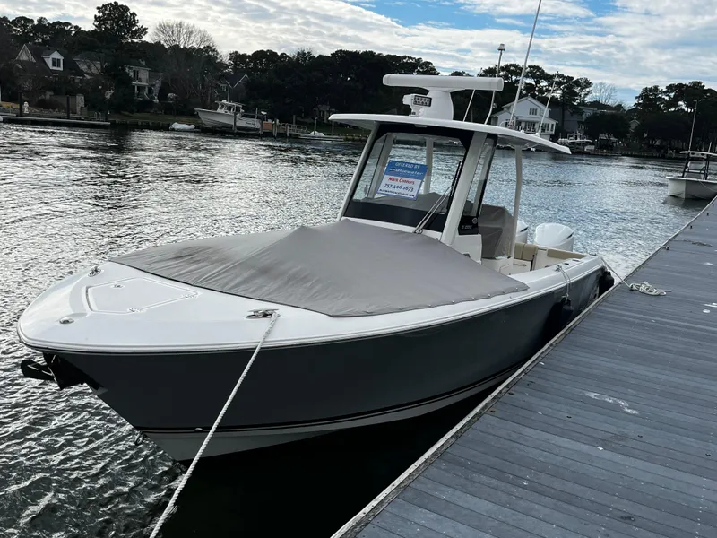 Slide: The Image of 2019 Pursuit S 288 Sport boat docked by the water. - 28