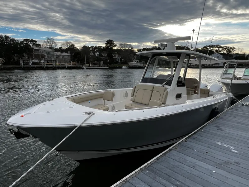 Slide: The Image of 2019 Pursuit S 288 Sport boat docked by the water on a cloudy day. - 33