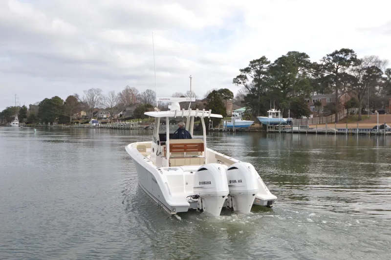 Slide: The Image of 2019 Pursuit S 288 Sport boat with twin Yamaha engines on a calm waterway. - 6