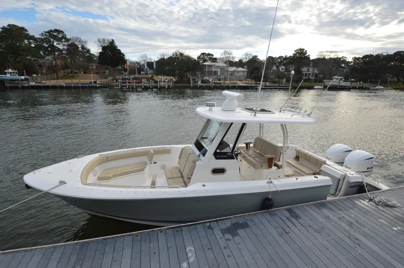 Slide: The Image of 2019 Pursuit S 288 Sport boat docked by a waterfront neighborhood. - 9