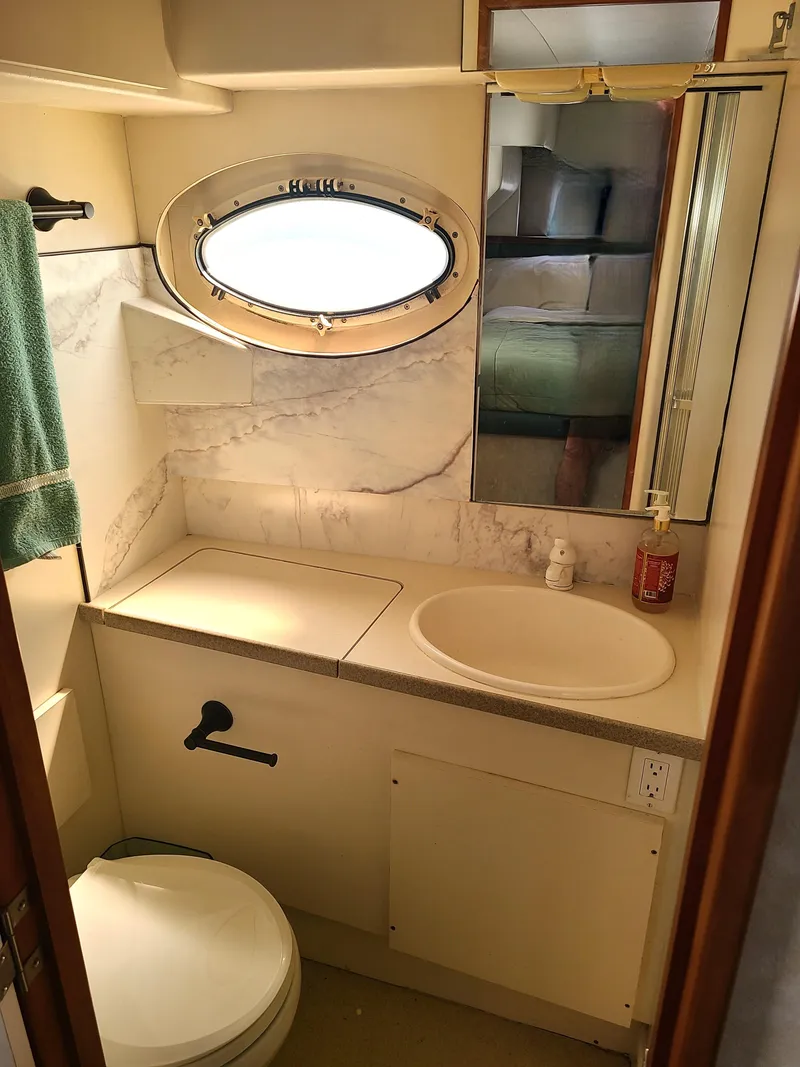 Slide: The Image of Bathroom interior of 1997 Silverton 372 Motor Yacht with oval window and marble accents. - 10