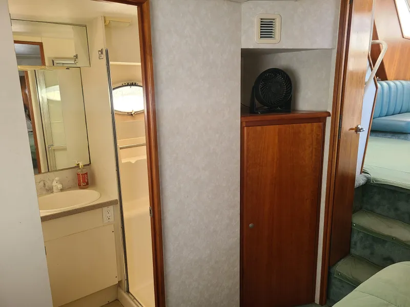 Slide: The Image of 1997 Silverton 372 Motor Yacht interior with bathroom, wooden cabinet, and stairs. - 11