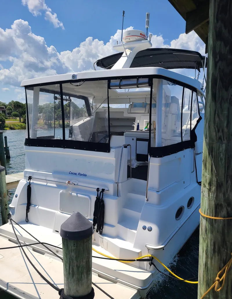 Slide: The Image of 1997 Silverton 372 Motor Yacht docked, featuring a spacious rear deck and clear skies. - 15