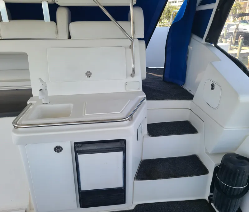 Slide: The Image of 1997 Silverton 372 Motor Yacht interior with kitchenette and stairs, featuring white and blue accents. - 17
