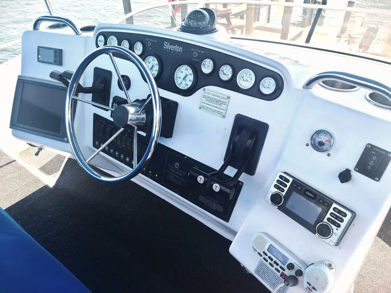 Slide: The Image of 1997 Silverton 372 Motor Yacht dashboard with steering wheel and navigation instruments. - 19