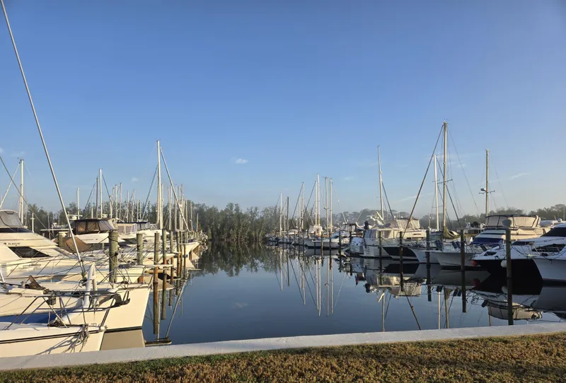 Slide: The Image of Boats docked at a marina under clear blue skies, featuring a 1997 Silverton 372 Motor Yacht. - 23