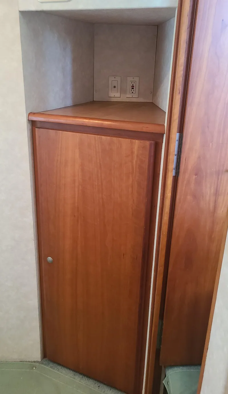 Slide: The Image of 1997 Silverton 372 Motor Yacht interior cabinet with wood finish and electrical outlets. - 25