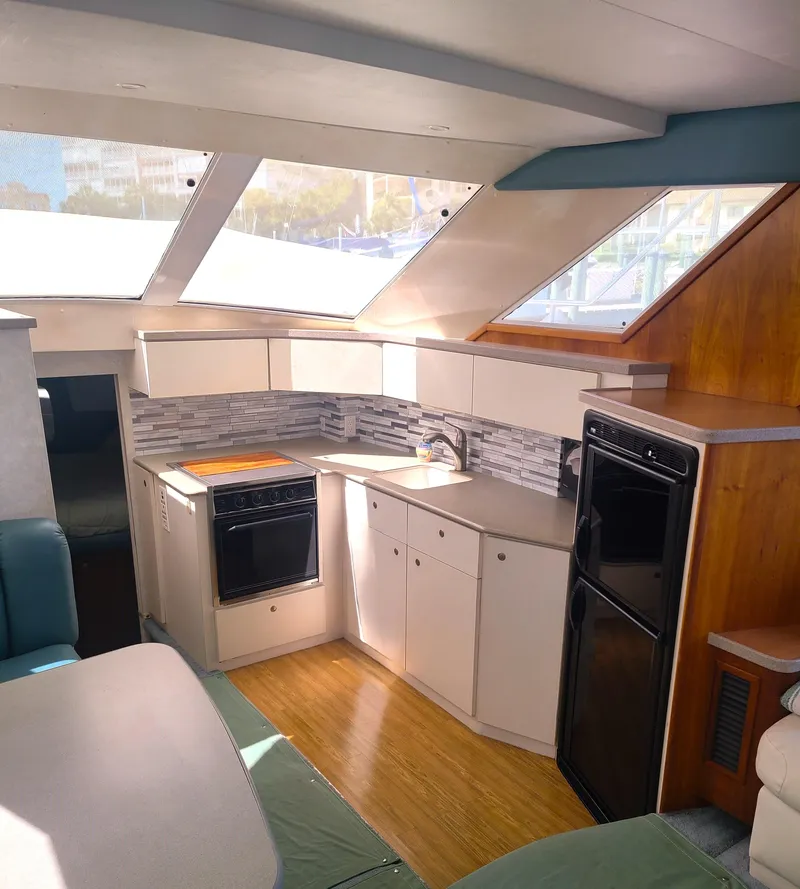 Slide: The Image of Interior of 1997 Silverton 372 Motor Yacht with modern kitchen and ample natural light. - 3