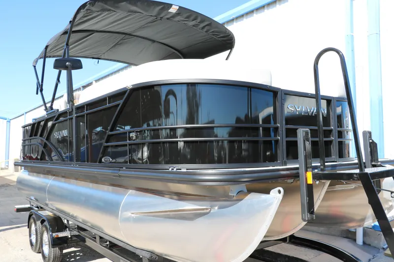 Slide: The Image of 2024 Sylvan Mirage 8522 Party Fish pontoon boat with black canopy on trailer. - 8