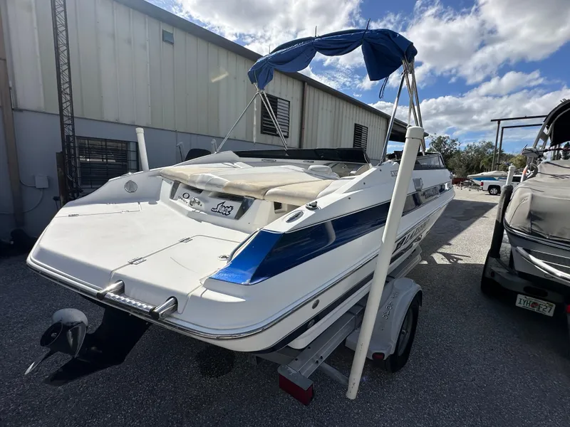 Slide: The Image of 2006 Larson LXi 208 boat on trailer, parked outdoors near a building. - 3