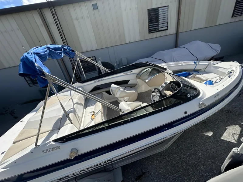 Slide: The Image of 2006 Larson LXi 208 boat with blue canopy in storage. - 4