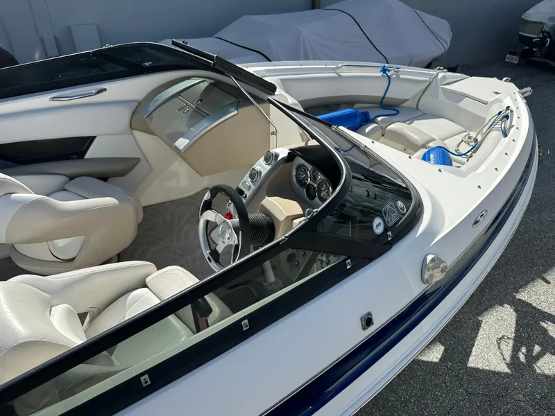 Slide: The Image of 2006 Larson LXi 208 boat interior with white seats and steering wheel. - 5