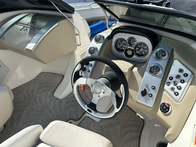 Slide: The Image of 2006 Larson LXi 208 boat dashboard with steering wheel and control panel. - 8
