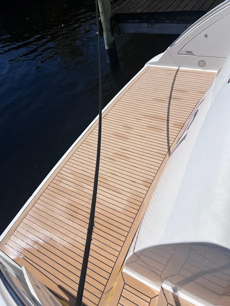 Slide: The Image of 2005 Azimut 55 Flybridge yacht deck with wooden finish by the water. - 14
