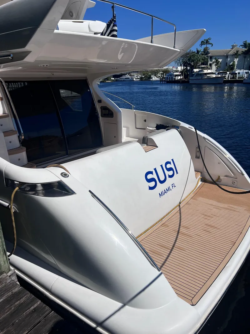 Slide: The Image of 2005 Azimut 55 Flybridge yacht docked, featuring spacious deck and sleek design. - 15