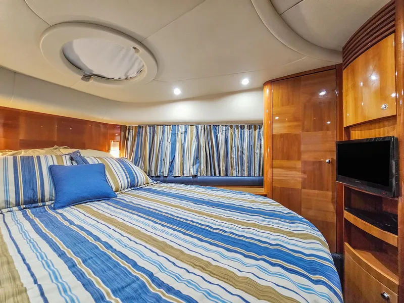 Slide: The Image of Luxurious bedroom in a 2005 Azimut 55 Flybridge yacht with striped bedding. - 30