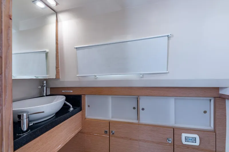 Slide: The Image of Modern bathroom interior on 2017 Fjord 40 Open yacht, featuring sleek sink and wooden cabinetry. - 16
