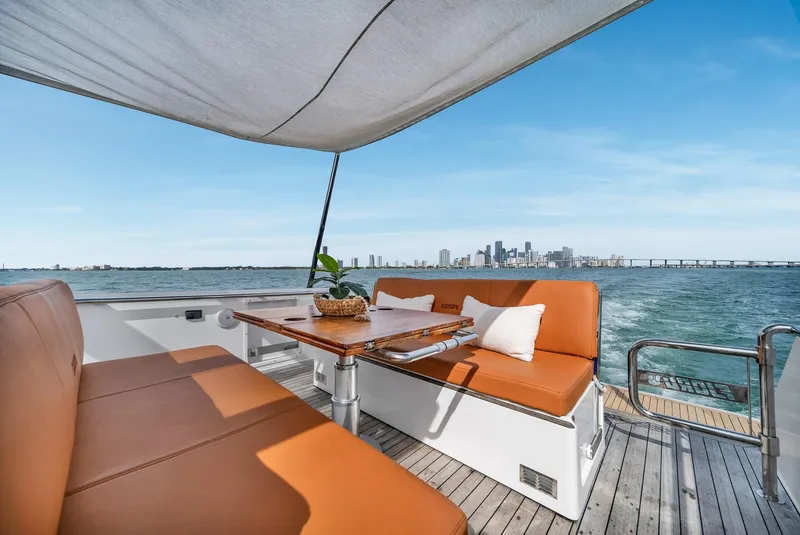 Slide: The Image of Luxurious 2017 Fjord 40 Open yacht with elegant seating, ocean view, and city skyline backdrop. - 5