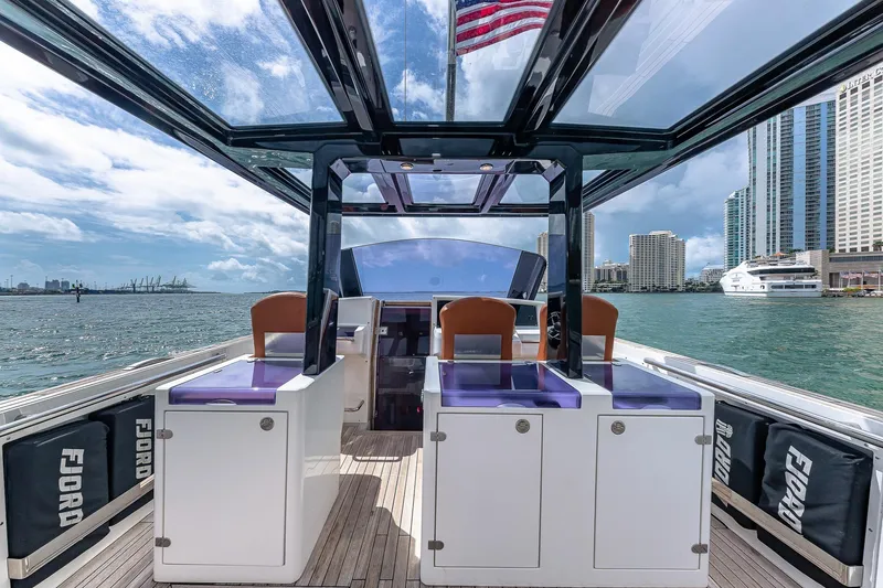 Slide: The Image of 2017 Fjord 40 Open yacht interior with city skyline and American flag in the background. - 7