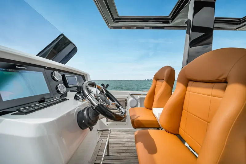 Slide: The Image of 2017 Fjord 40 Open boat interior with modern dashboard and leather seats, ocean view. - 8