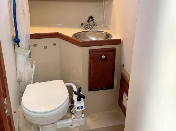 Slide: The Image of 1988 Catalina 30 MkII boat bathroom with toilet, sink, and wooden accents. - 11