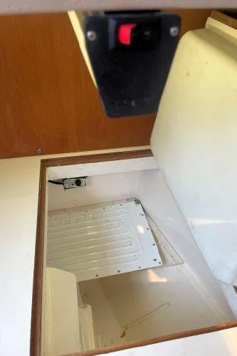 Slide: The Image of Interior compartment of a 1988 Catalina 30 MkII sailboat, featuring storage space and a switch. - 13