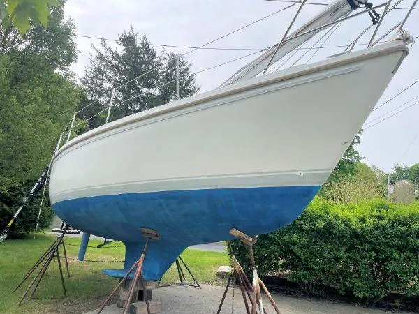 Slide: The Image of 1988 Catalina 30 MkII sailboat on stands, white hull with blue bottom, outdoors. - 26