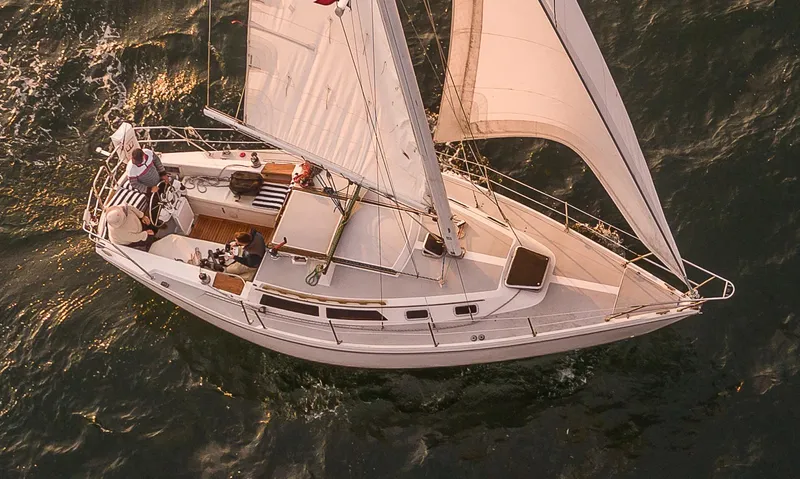 Slide: The Image of 1988 Catalina 30 MkII sailboat navigating ocean waters at sunset. - 3