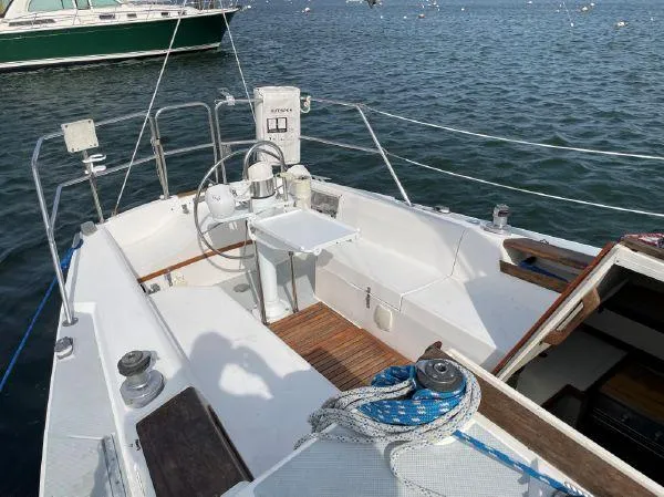Slide: The Image of 1988 Catalina 30 MkII sailboat cockpit with steering wheel and seating, docked on calm water. - 4