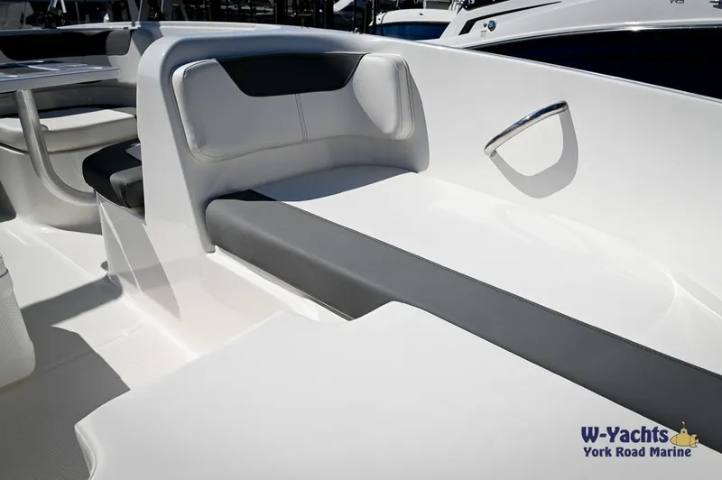 Slide: The Image of 2023 Bayliner E18 boat interior with white and gray seating, shown at W-Yachts York Road Marine. - 10