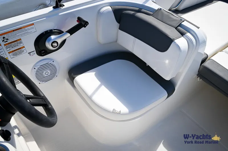 Slide: The Image of 2023 Bayliner E18 boat cockpit with steering wheel and control lever. - 11