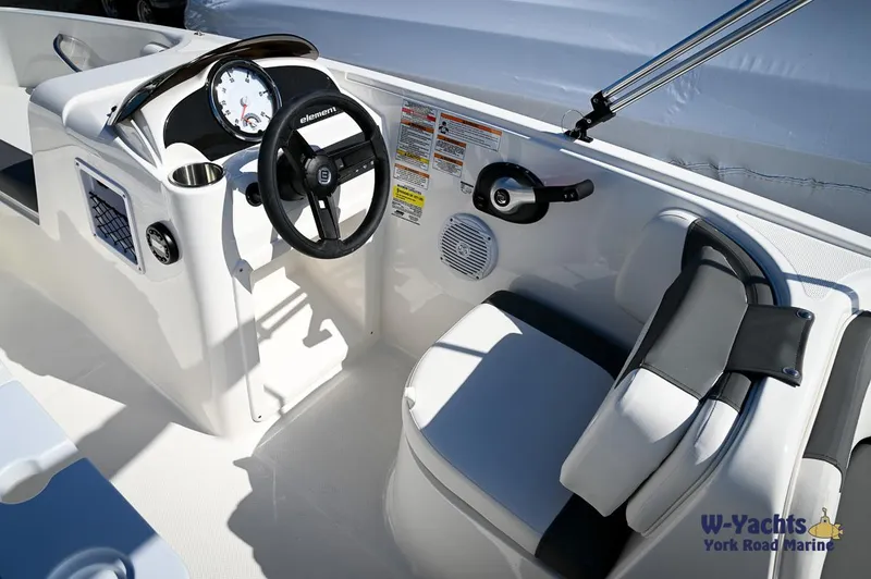 Slide: The Image of 2023 Bayliner E18 boat interior with steering wheel and seating. - 12