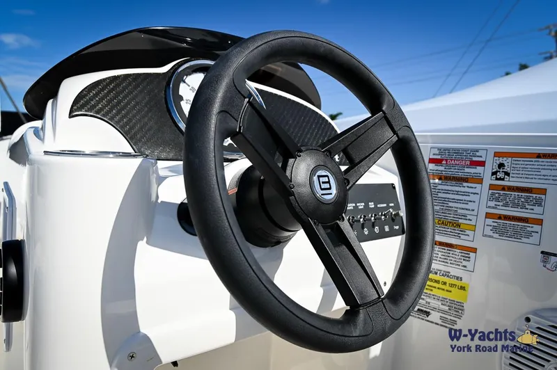 Slide: The Image of 2023 Bayliner E18 boat steering wheel and dashboard close-up. - 13