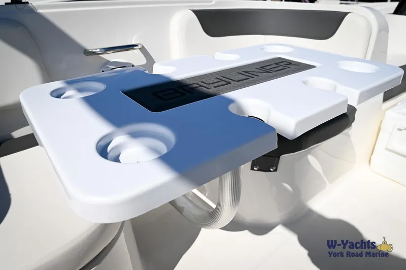 Slide: The Image of 2023 Bayliner E18 boat interior with cup holders and Bayliner logo. - 15